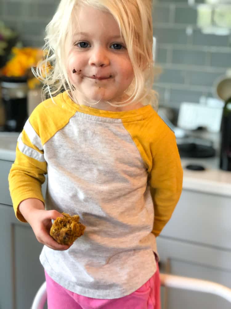 toddler holding and eating dairy free pumpkin muffin 