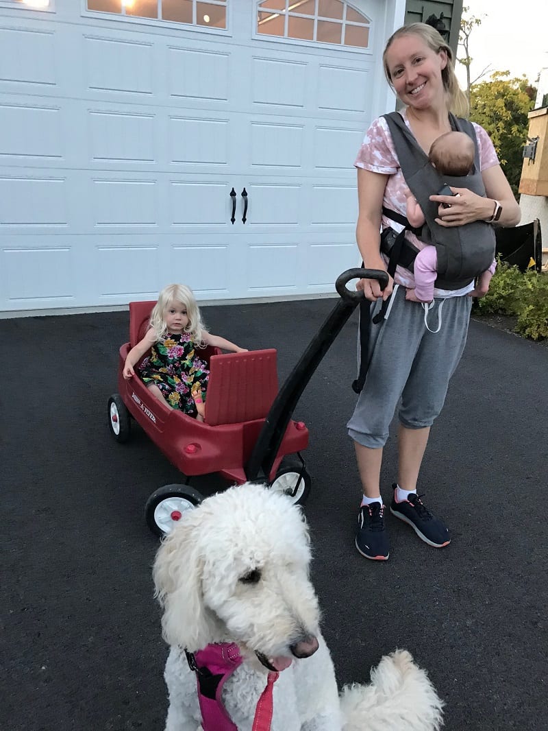 mom holding baby and pulling wagon