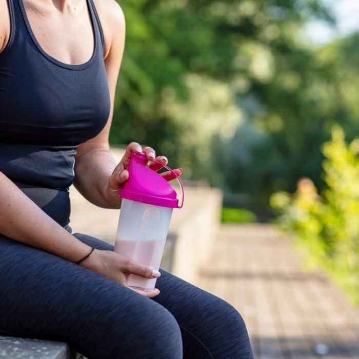 woman holding pre workout coffee shake because Coffee before running can help improve performance