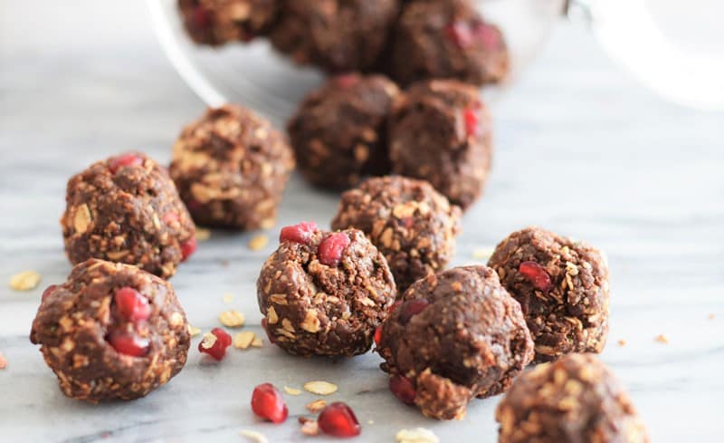 date energy bites with pomegranate seeds on granite countertop