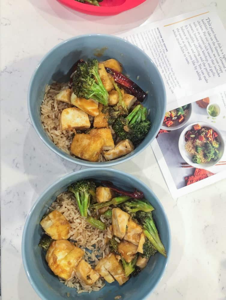 Rice and tofu with broccoli served in blue serving bowls