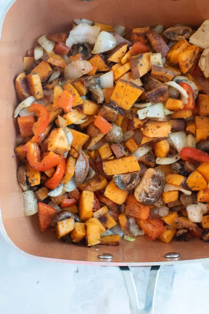 pan with diced sweet potatoes, onions, mushrooms and peppers