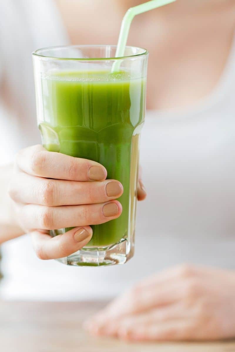 clear glass with green juice and straw