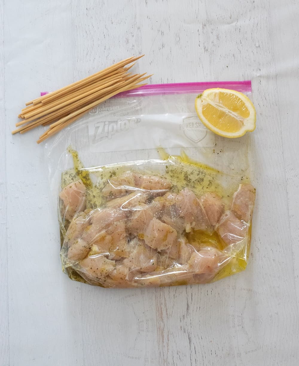 grilled chicken marinating in ziplock bag with oil and lemon