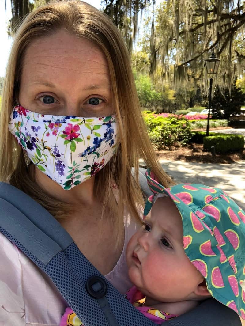 mom with mask holding baby in carrier