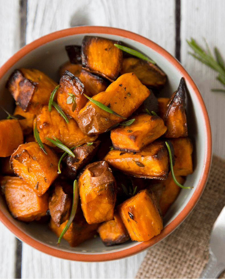 Bowl of sweet potatoes with herbs on top