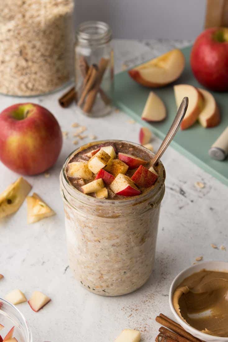 cottage cheese overnight oats in mason jar with apple pie seasoning on countertop with sliced apples in background